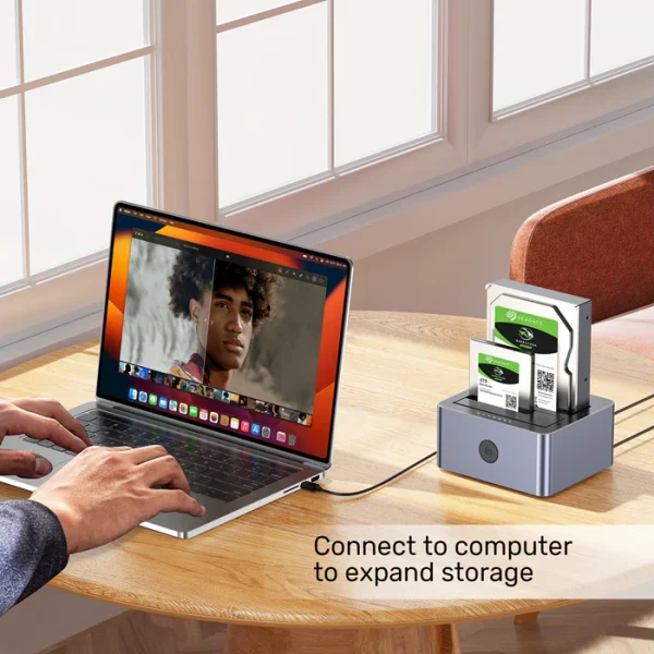 Dock ổ cứng Unitek Y-3026GY01-EU kết nối MacBook Pro M-series qua USB mở rộng lưu trữ với 2 ổ Seagate BarraCuda 4TB — người dùng chỉnh ảnh chân dung trên MacBook, bối cảnh home office bàn gỗ tròn, ánh sáng tự nhiên