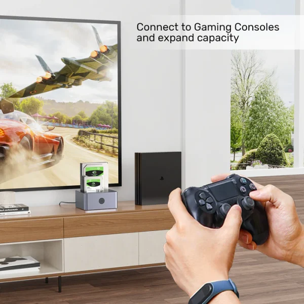 Dock ổ cứng Unitek Y-3026GY01-EU đặt cạnh PS4 Pro trong phòng khách — ổ Seagate BarraCuda HDD cắm sẵn mở rộng dung lượng lưu game, tay cầm DualShock 4, TV hiển thị game đua xe, kệ TV gỗ living room setup