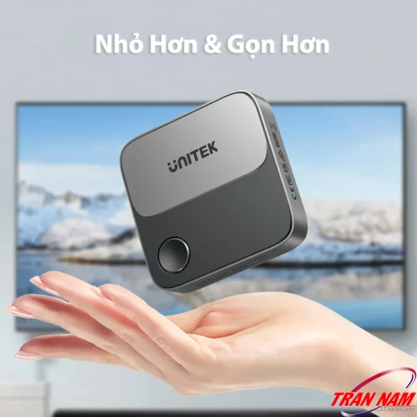 UNITEK V1162B01 nhỏ gọn nằm vừa lòng bàn tay, phía sau là TV kết nối không dây 4K